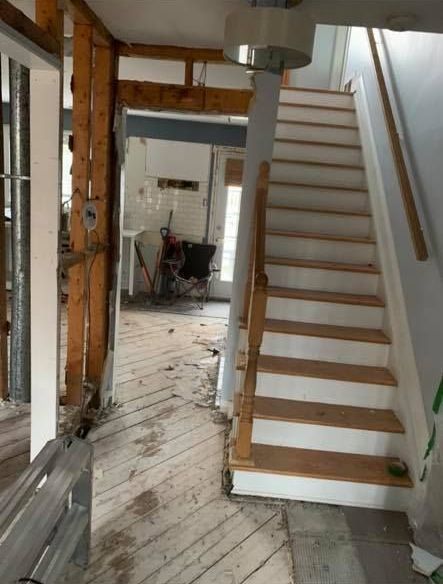 Un escalier blanc avec des marches en bois et une rampe en bois