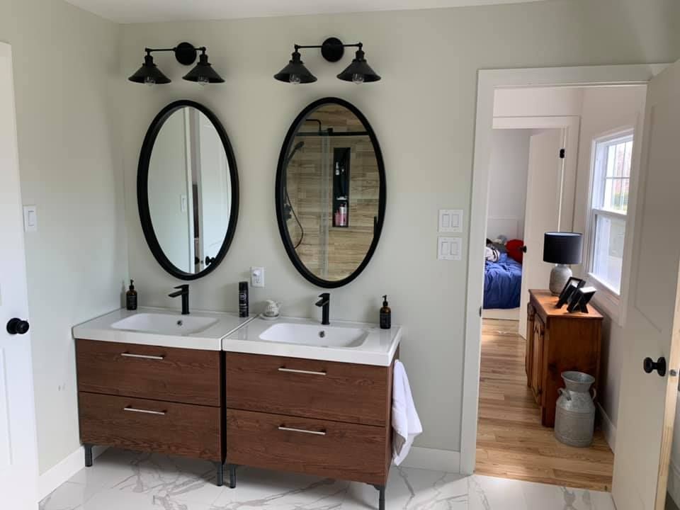 Une salle de bain avec deux lavabos et deux miroirs.