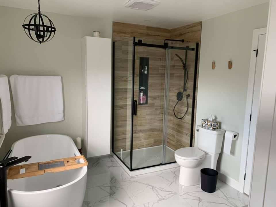 Une salle de bain avec baignoire, WC et douche.