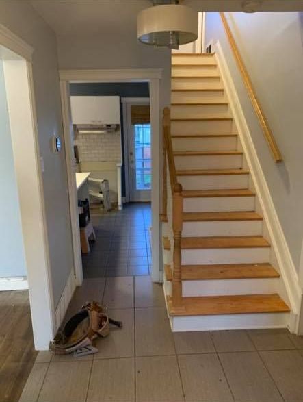 Un couloir avec des escaliers menant au deuxième étage d'une maison.