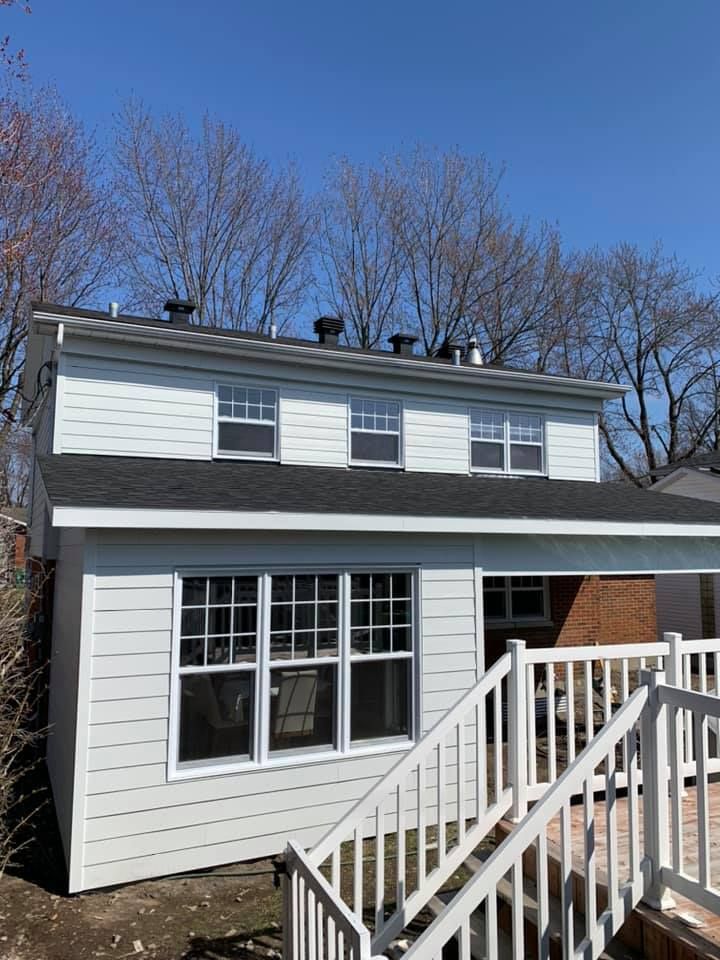 L'arrière d'une maison avec une terrasse et des escaliers qui y mènent.