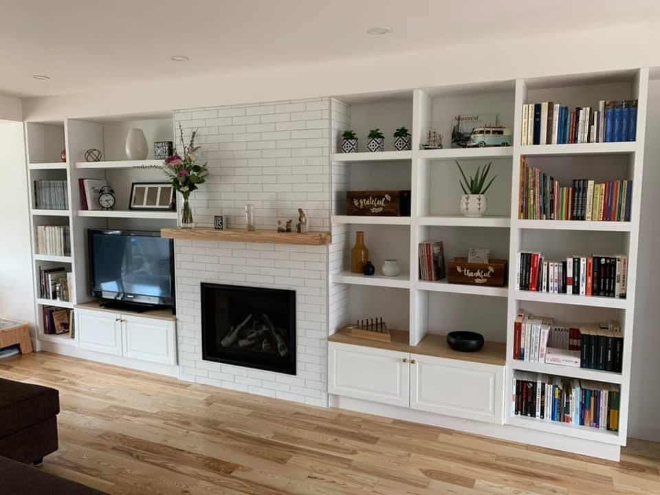Un salon avec une cheminée et de nombreuses étagères.
