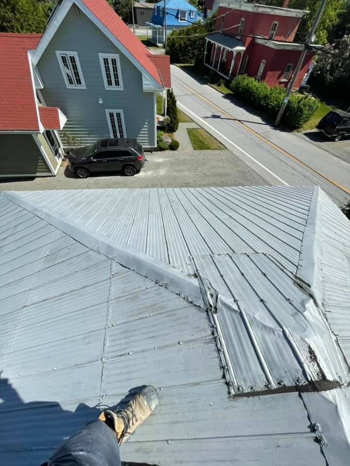 Une personne se tient sur le toit d'une maison.