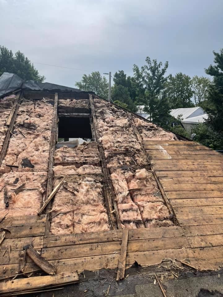 Le toit d'une maison est en train d'être démoli et il y a un trou dans le toit.