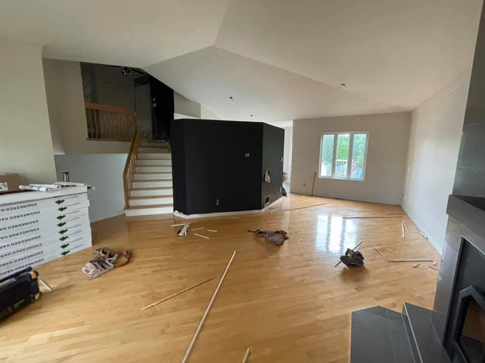 Un salon vide avec du parquet et une cheminée.