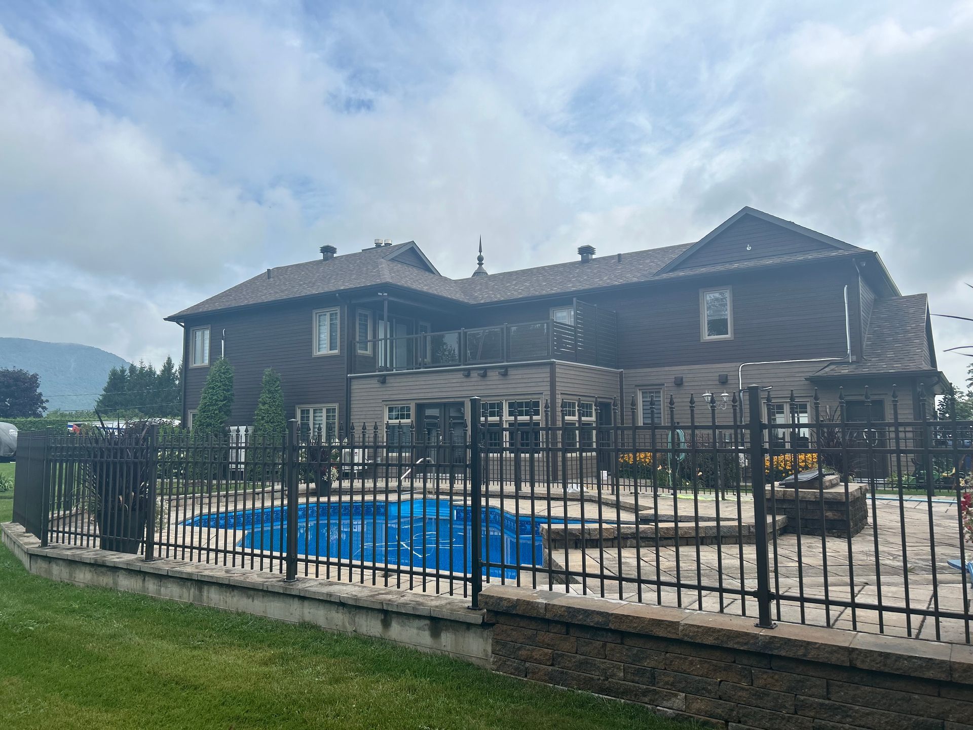 Une grande maison avec une piscine derrière une clôture.