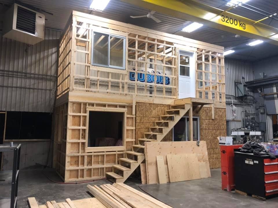 Une maison en bois est en construction dans une usine.