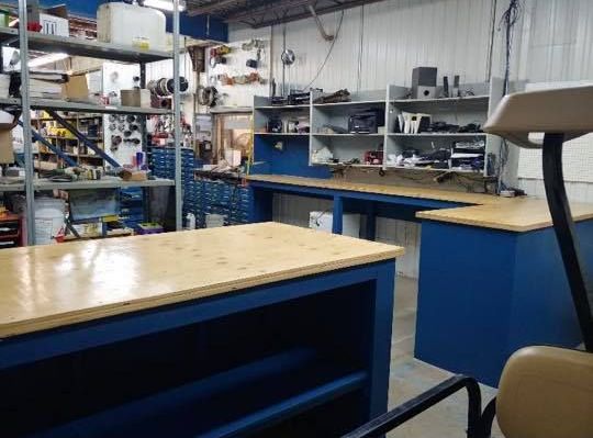 Une pièce avec beaucoup d'étagères, de tables et une chaise