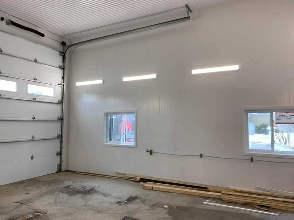 Un garage avec une porte de garage et deux fenêtres.