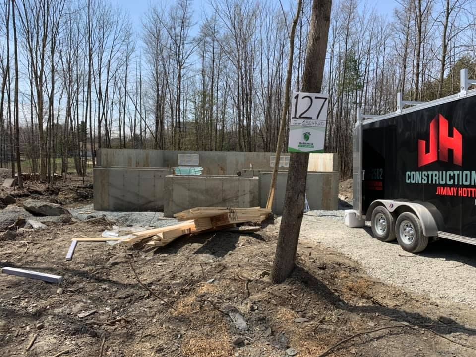 Une remorque de chantier est garée devant un bâtiment en construction.