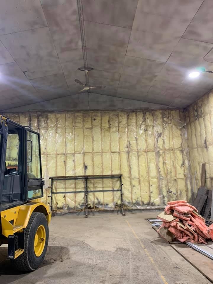 Un chariot élévateur jaune est garé à l'intérieur d'un bâtiment.