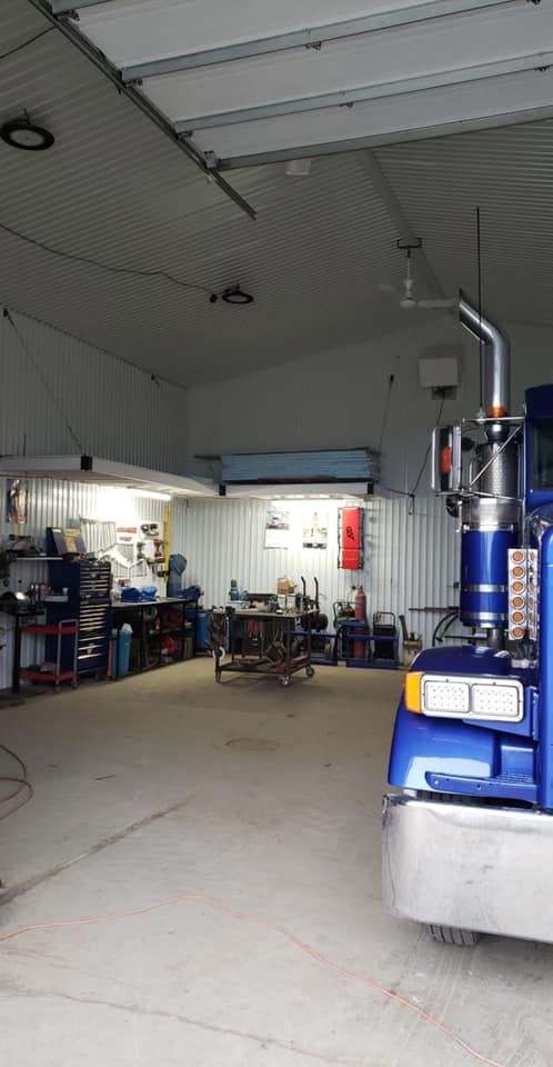 Un semi-remorque bleu est garé dans un garage.