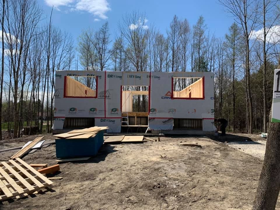 Une maison est en construction au milieu d'une forêt.