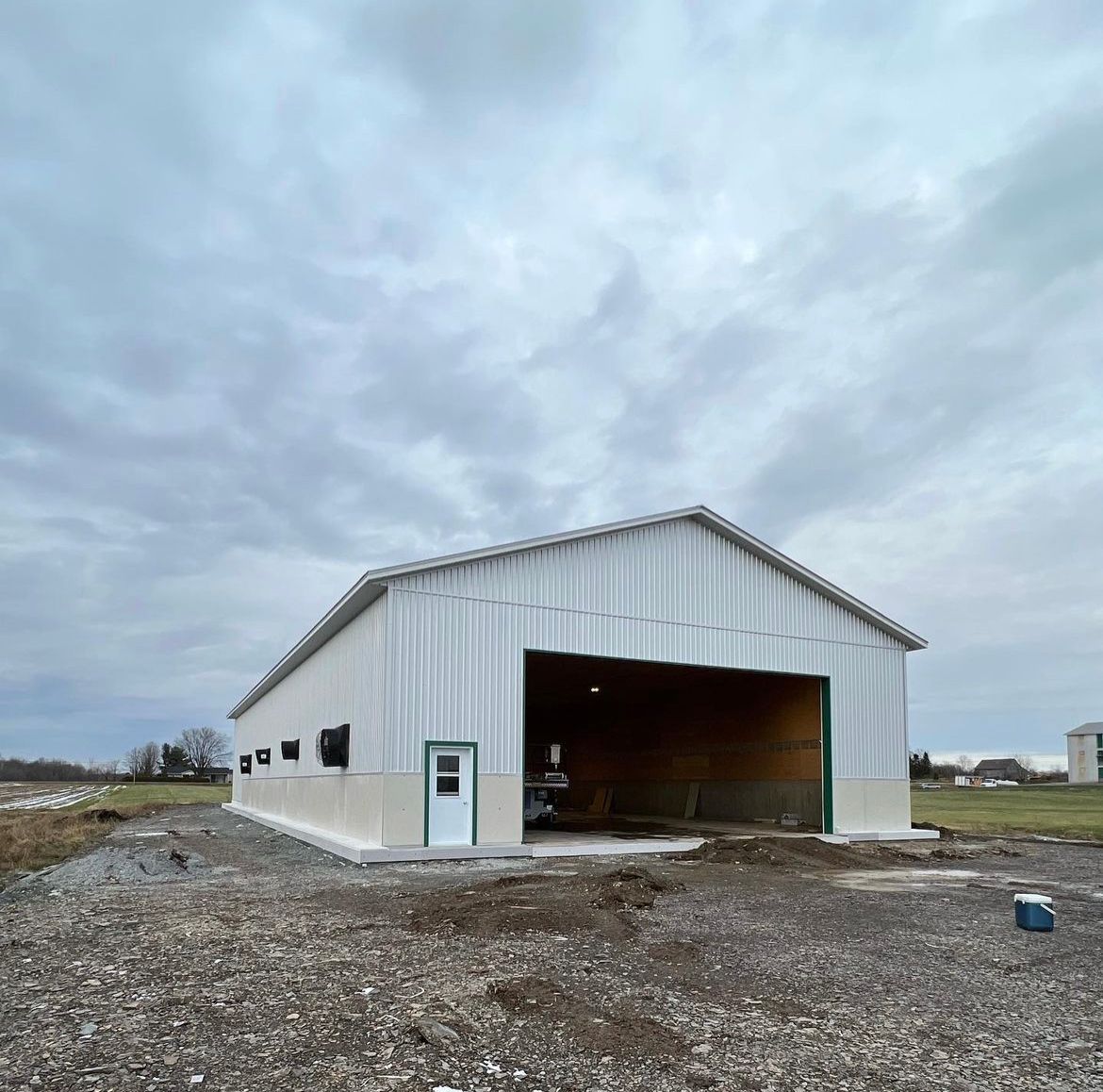 Un grand bâtiment blanc se trouve au milieu d'un champ de gravier.