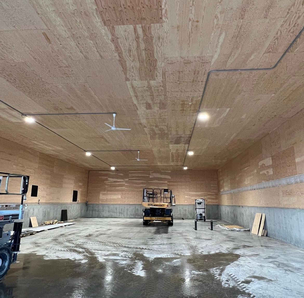 Un chariot élévateur est garé à l'intérieur d'un bâtiment avec un plafond en bois.