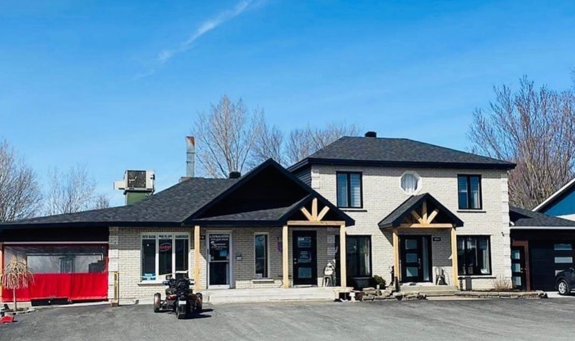 Une grande maison avec un tracteur garé devant.