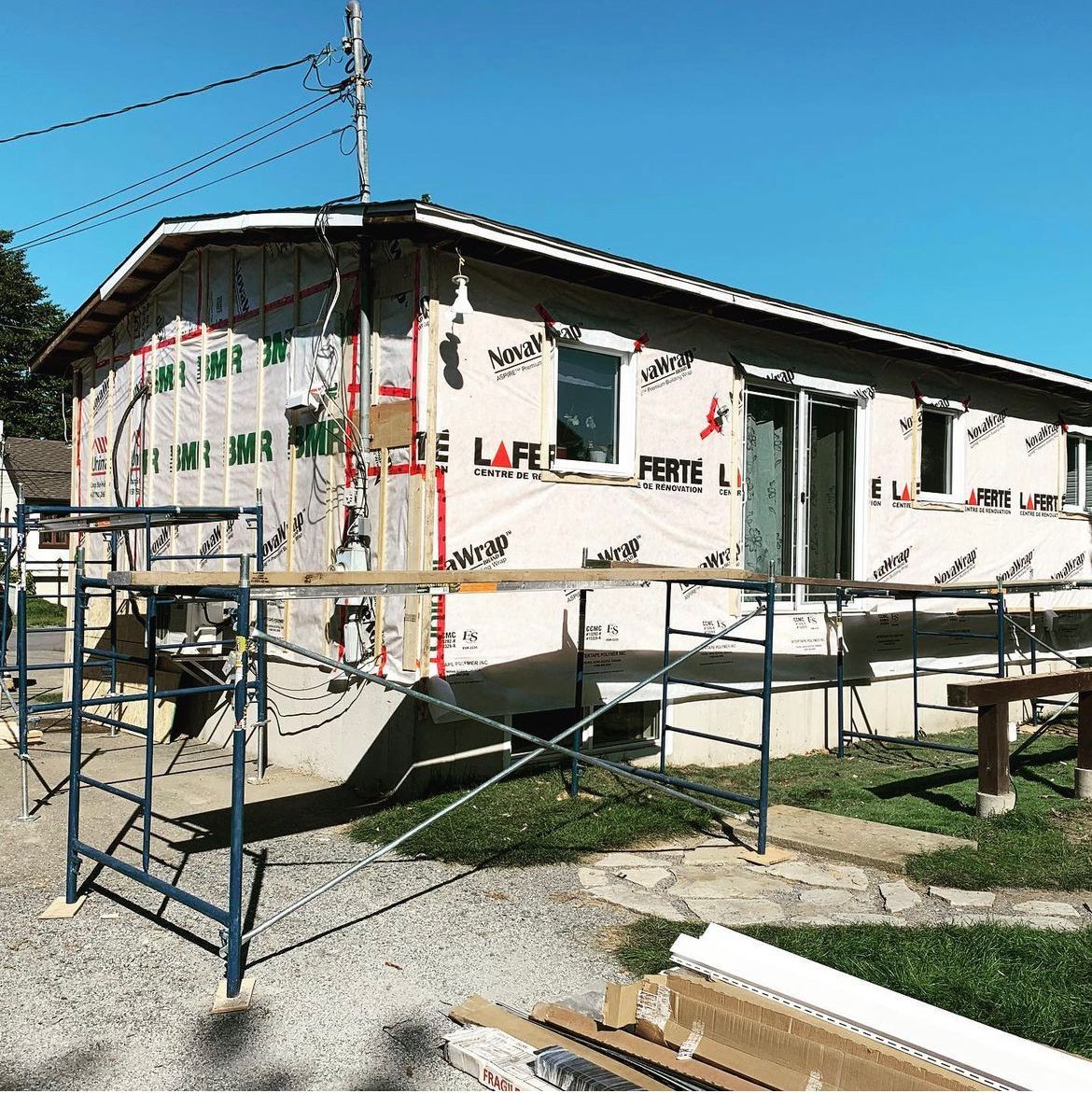 Une maison est en construction avec un échafaudage devant.