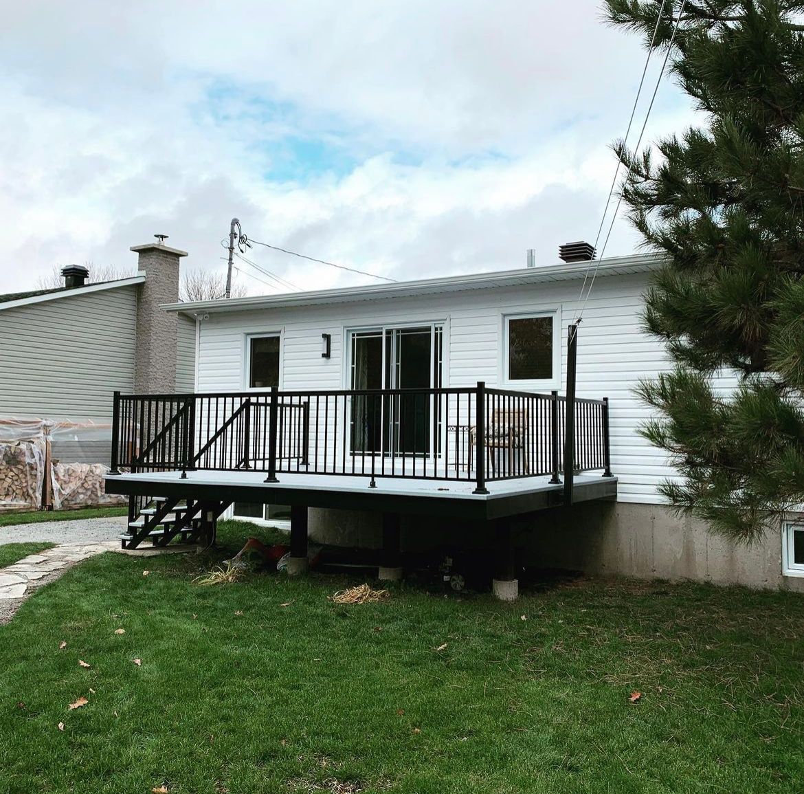 Une maison blanche avec une grande terrasse devant elle.