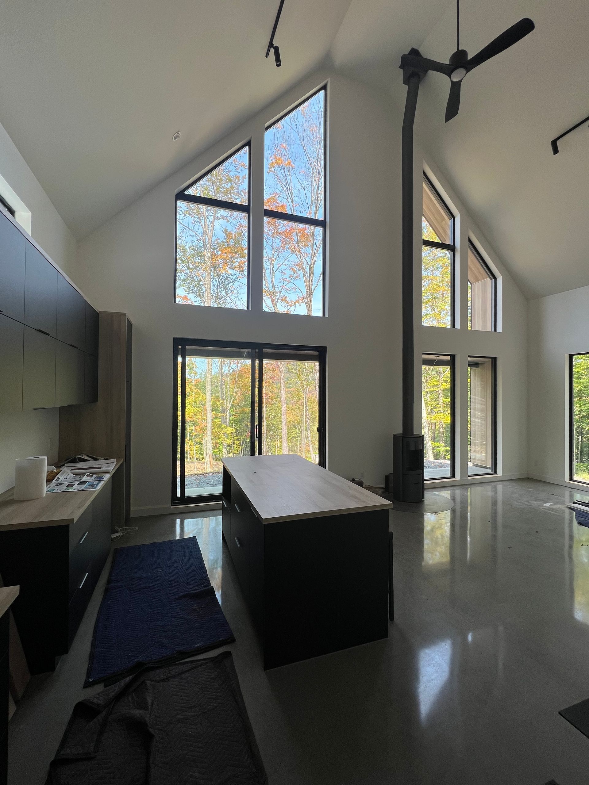 Une grande pièce avec beaucoup de fenêtres et un ventilateur de plafond