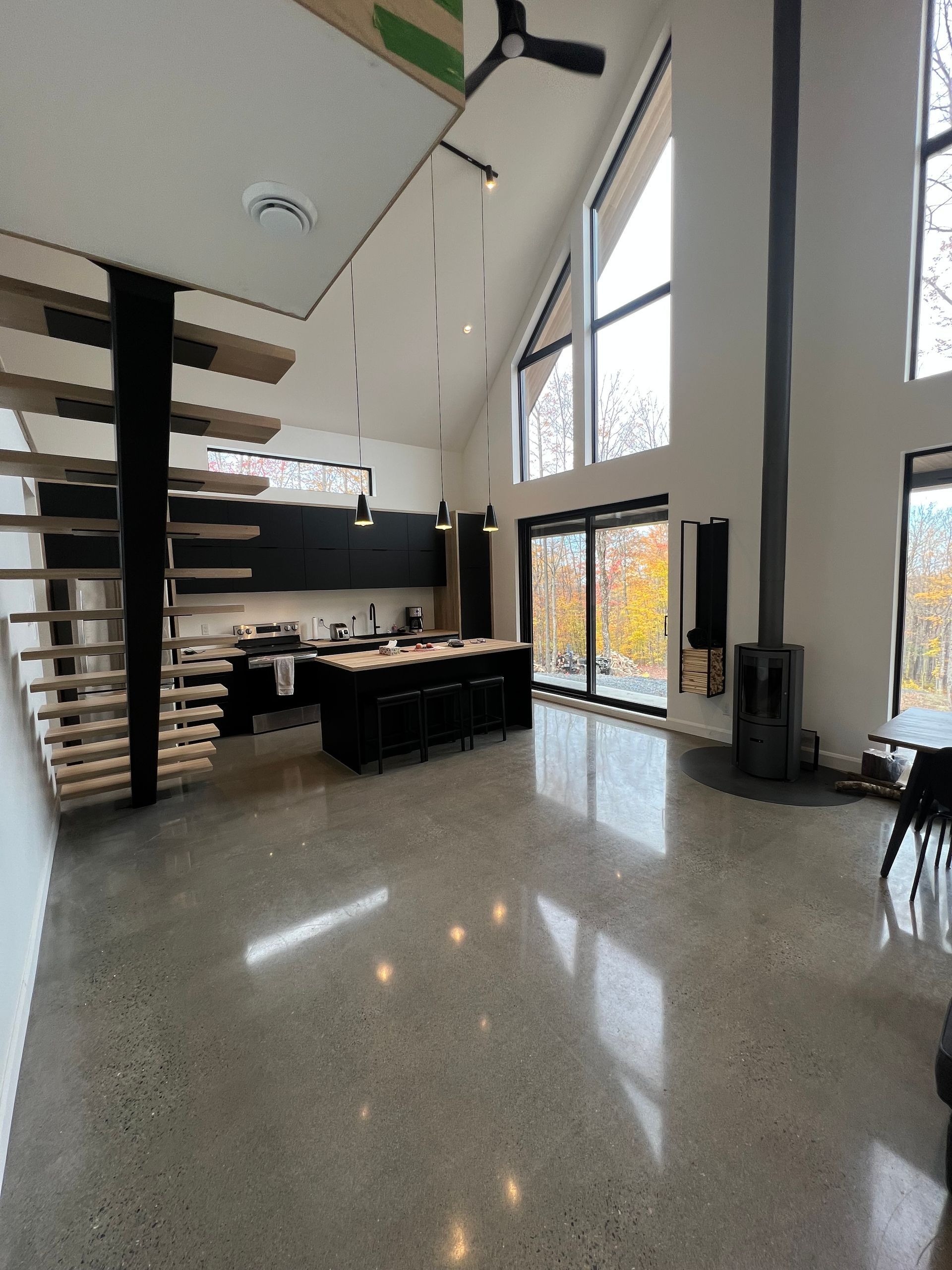 Une grande pièce avec une cuisine et des escaliers