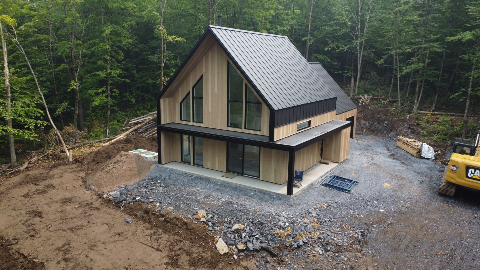 Une vue aérienne d'une maison en construction au milieu d'une forêt.