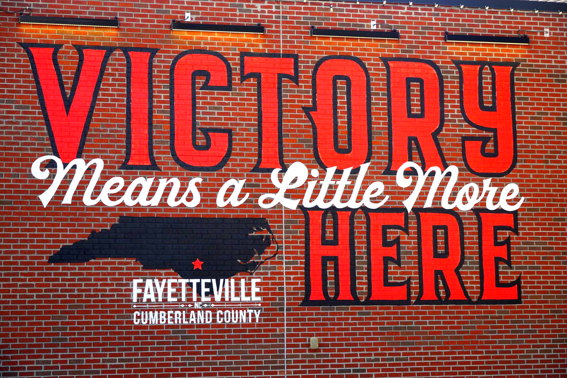 Victory Means a Little More Here mural in downtown Fayetteville NC | Local landmark featured by Realtor Alexander Carrasco | AgentNow.RealEstate