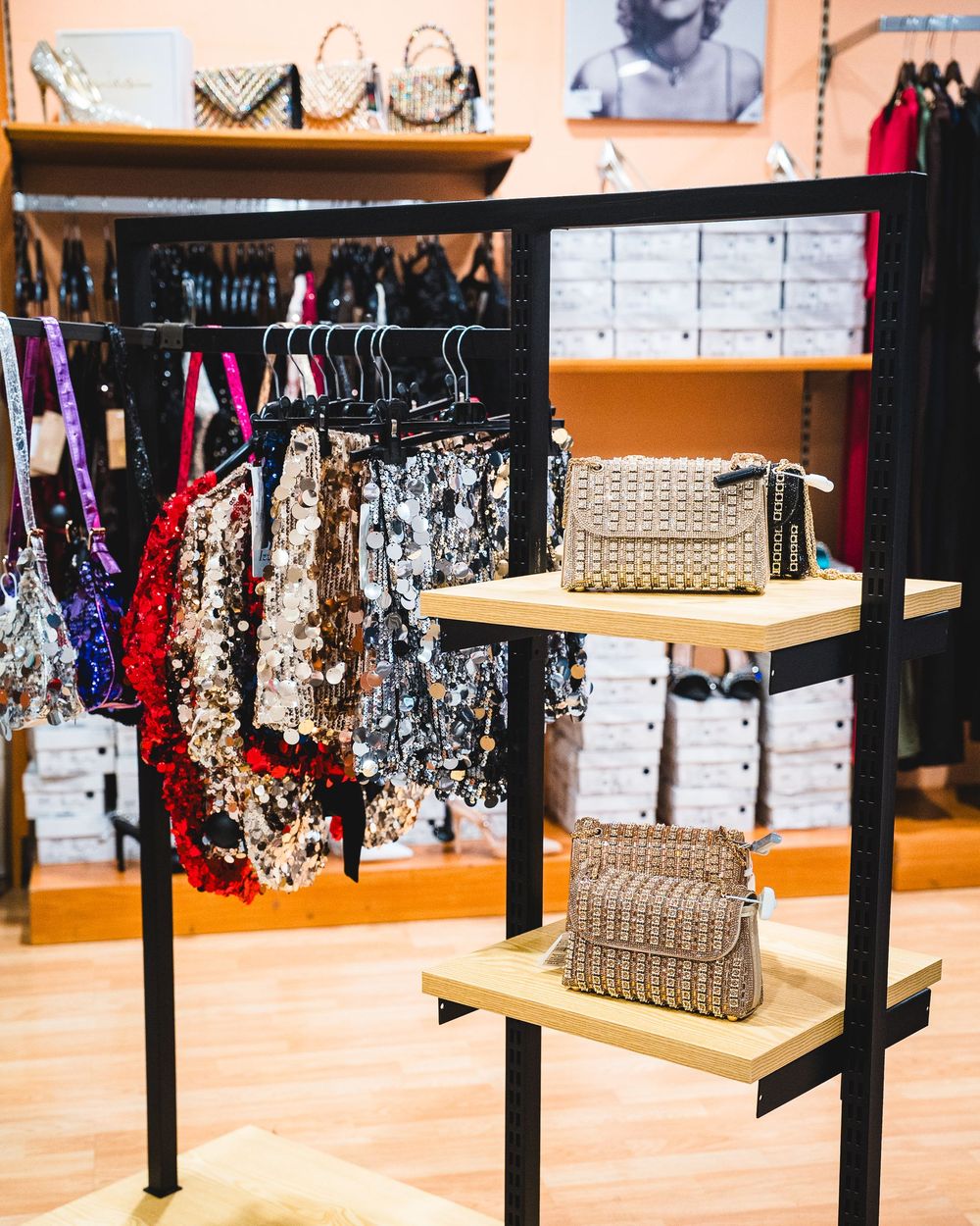 Esposizione di un negozio di abbigliamento con borse sugli scaffali e appese agli scaffali.