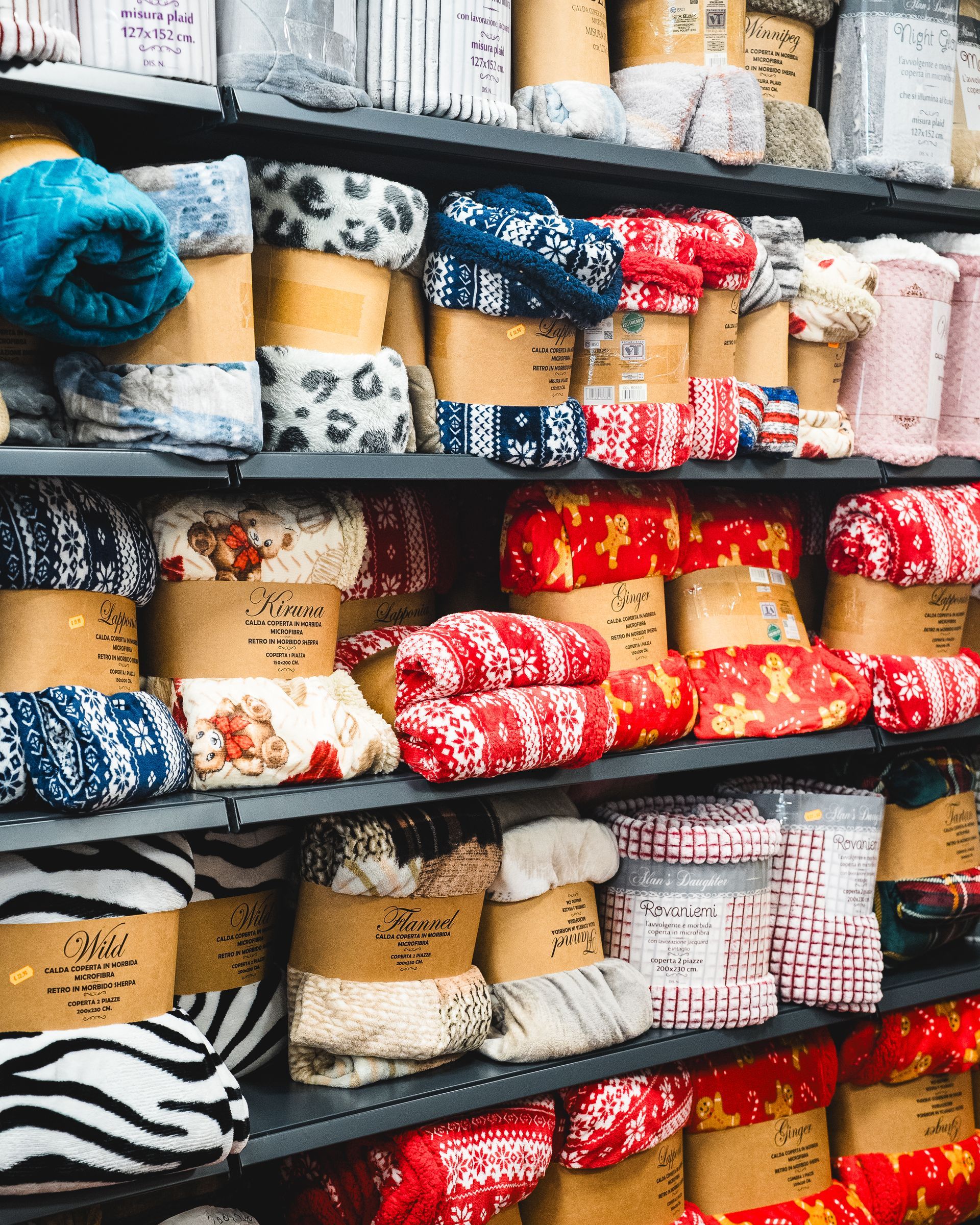 Scaffali pieni di tessuti arrotolati: con stampe animalier, fantasie e temi natalizi.