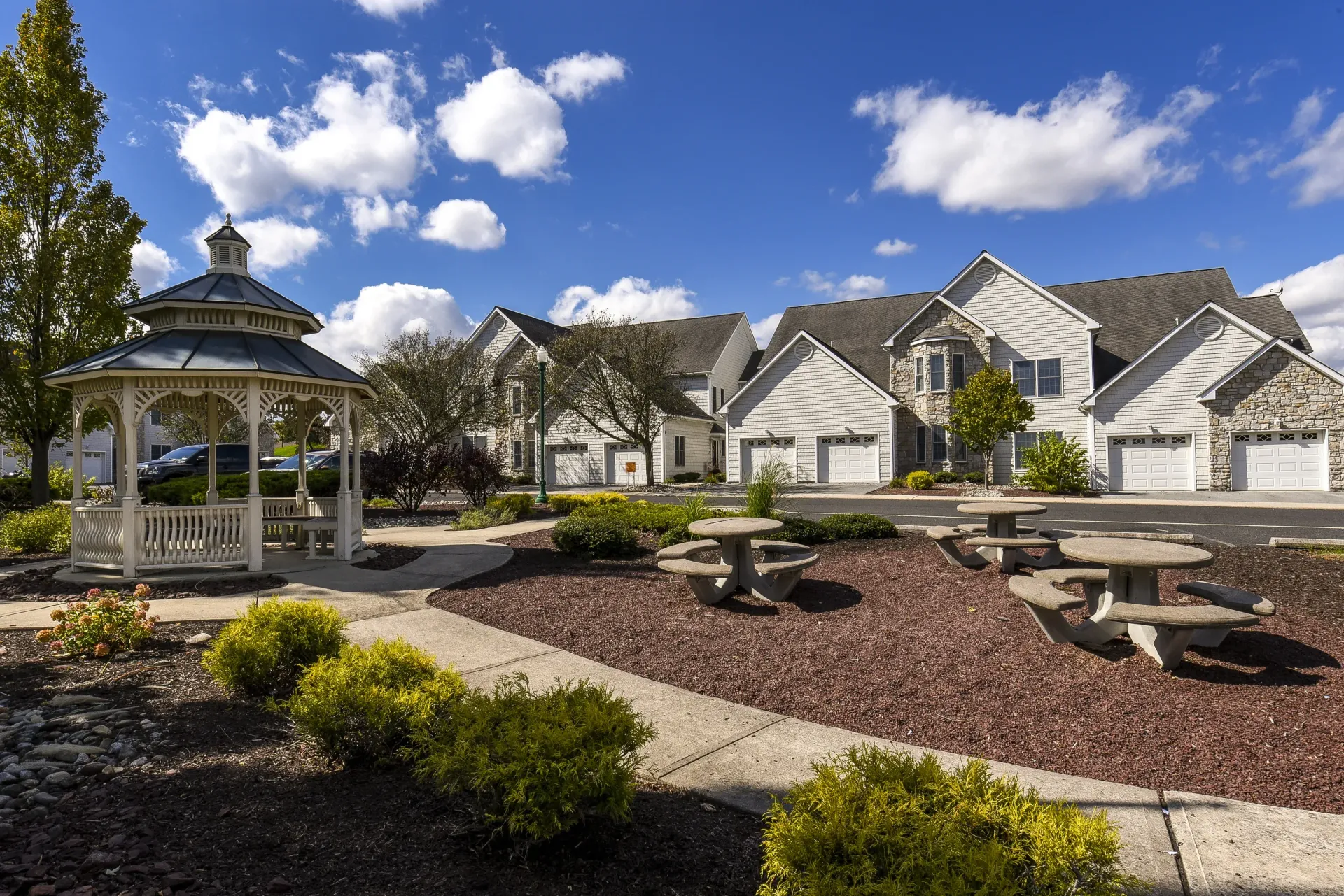 White gazebo in a landscaped apartment community courtyard at Springhouse Townhomes in Allentown, PA.