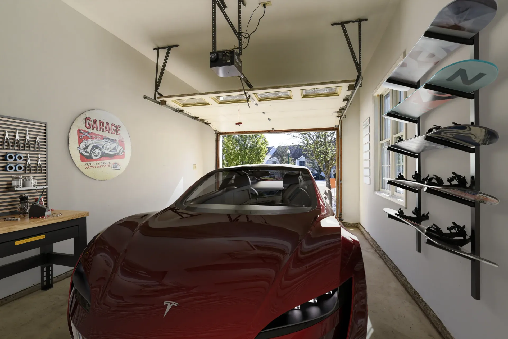 Red car parked in a residential garage with a workbench and surfboards on the wall at Springhouse Townhomes in Allentown, PA.