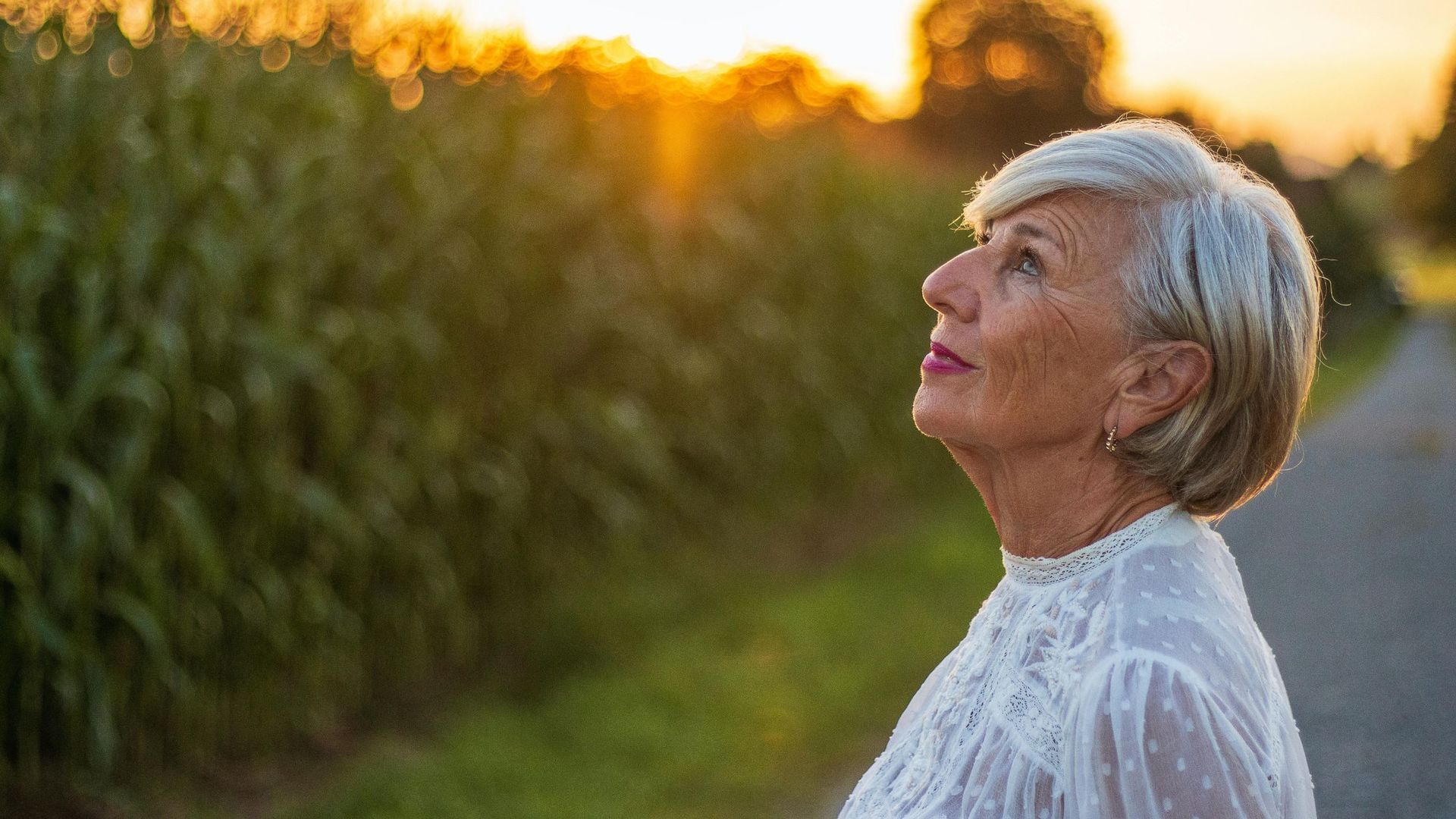 Senior woman looking up at a sunset