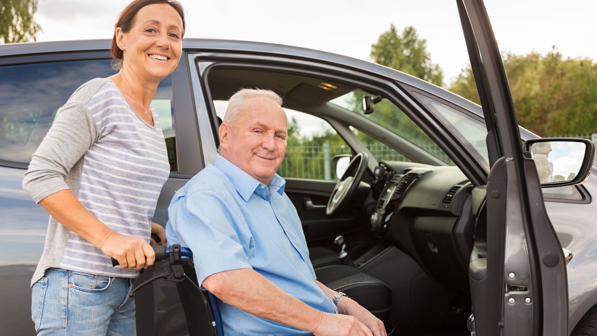 Family member helping a loved one into the car