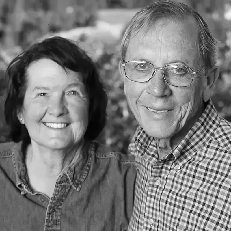 A black and white photo of a man and a woman smiling for the camera.
