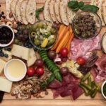 A wooden cutting board filled with lots of different types of food.