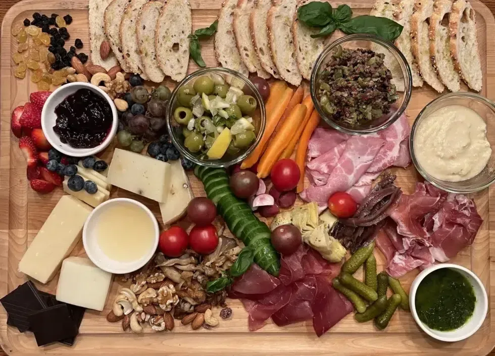 A wooden cutting board filled with lots of different types of food.