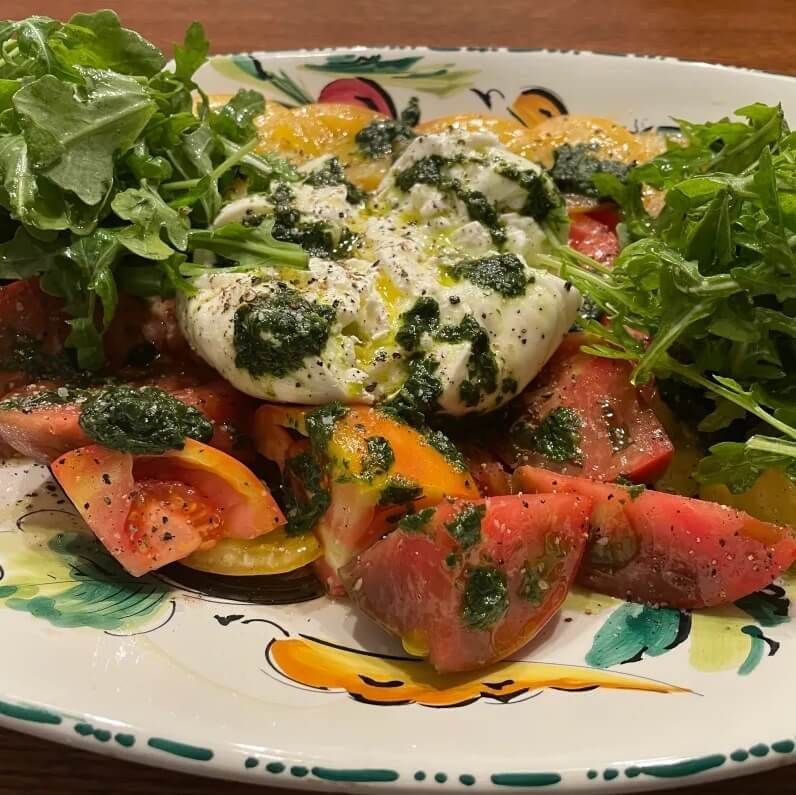 A plate of food with tomatoes , eggs , and lettuce on a table.