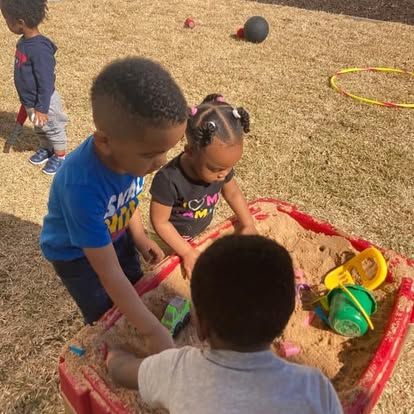 A group of children are playing in a sandbox.