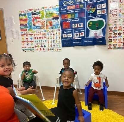 A group of children are sitting in a room with posters on the wall that say circle time