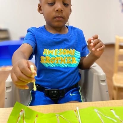 A young boy in a blue shirt that says awesome brother