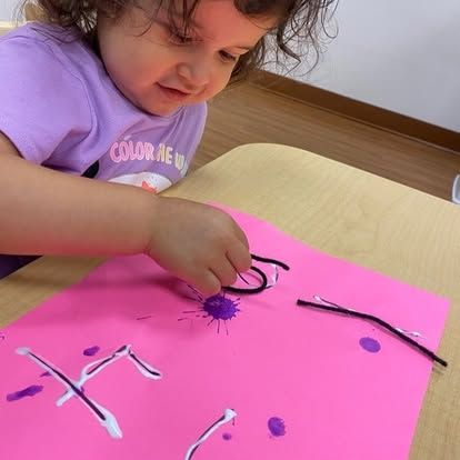 A little girl wearing a purple shirt that says color me up