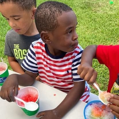 A boy wearing a shirt that says the boss is eating ice cream