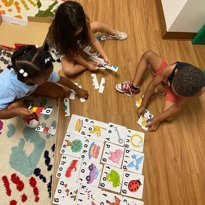 A group of children are playing a game on the floor