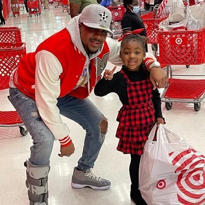 A man and a little girl are posing for a picture in a target store.