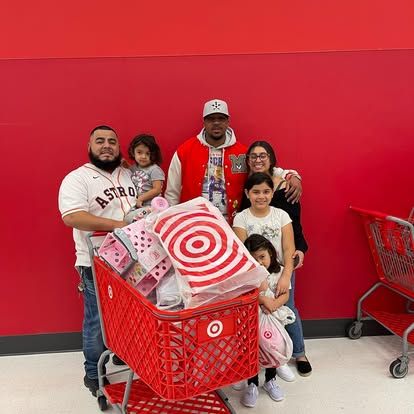 A man is pushing a shopping cart full of toys in a target store.
