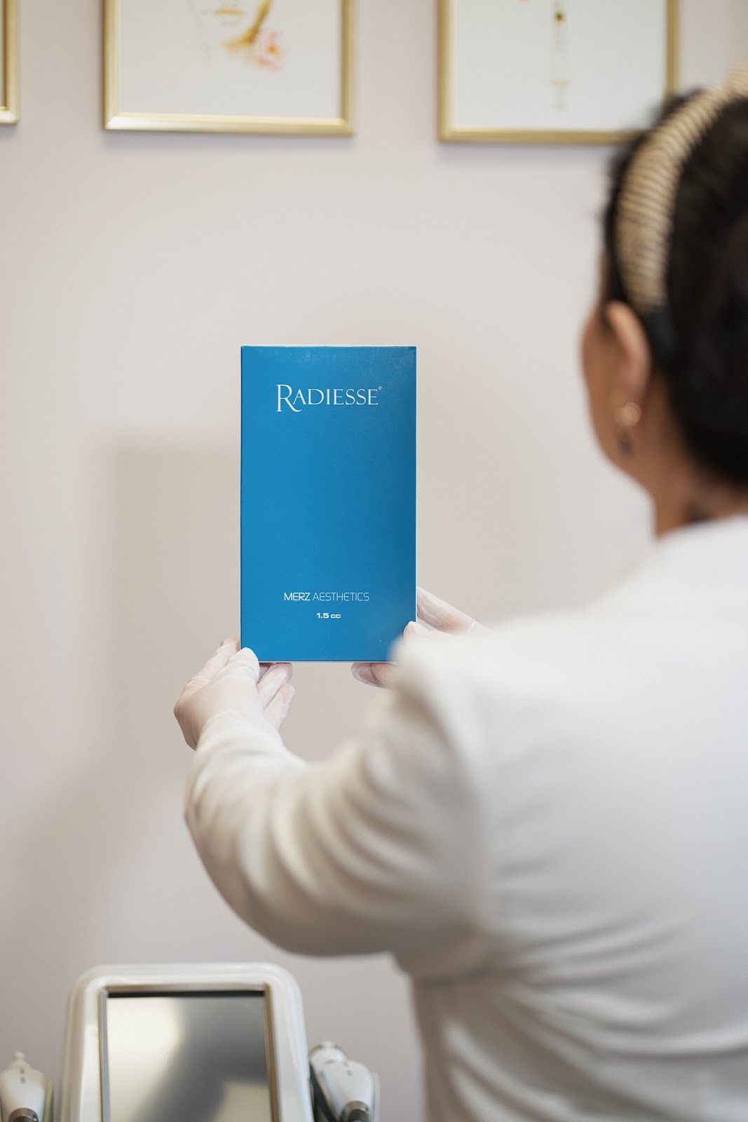 A person in a white coat holds a blue product box labeled 