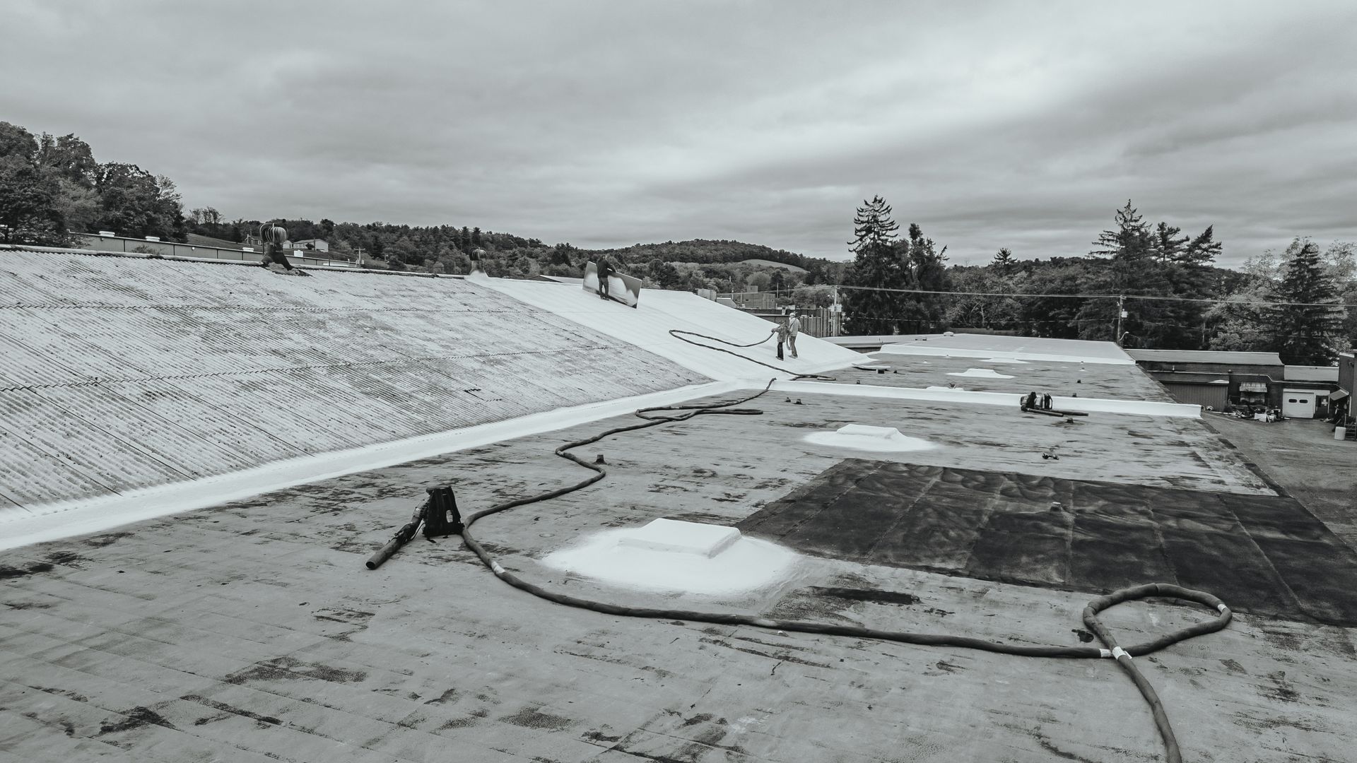 Rooftop with snow-covered slope, construction in progress, overcast sky.