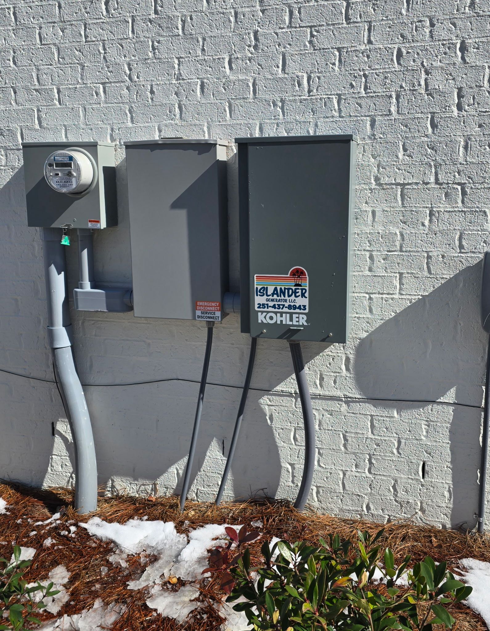 A brick wall with electrical boxes attached to it