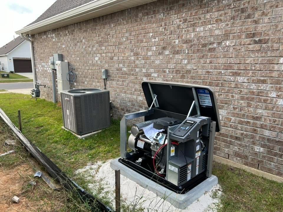 A generator is sitting in front of a brick house.