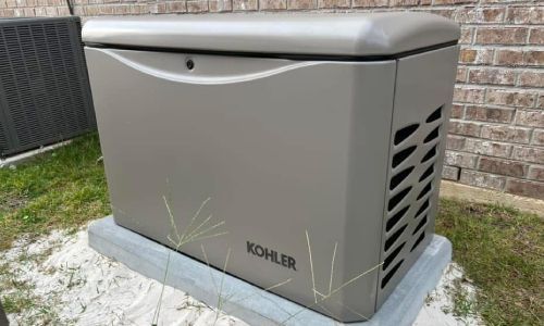 A kohler generator is sitting in front of a brick building.