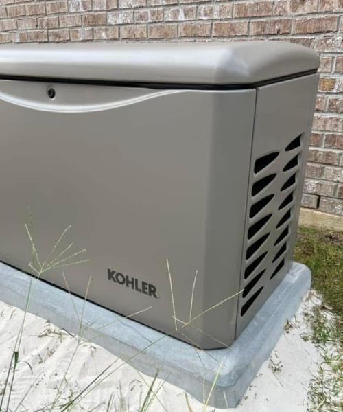 A kohler generator is sitting in front of a brick building